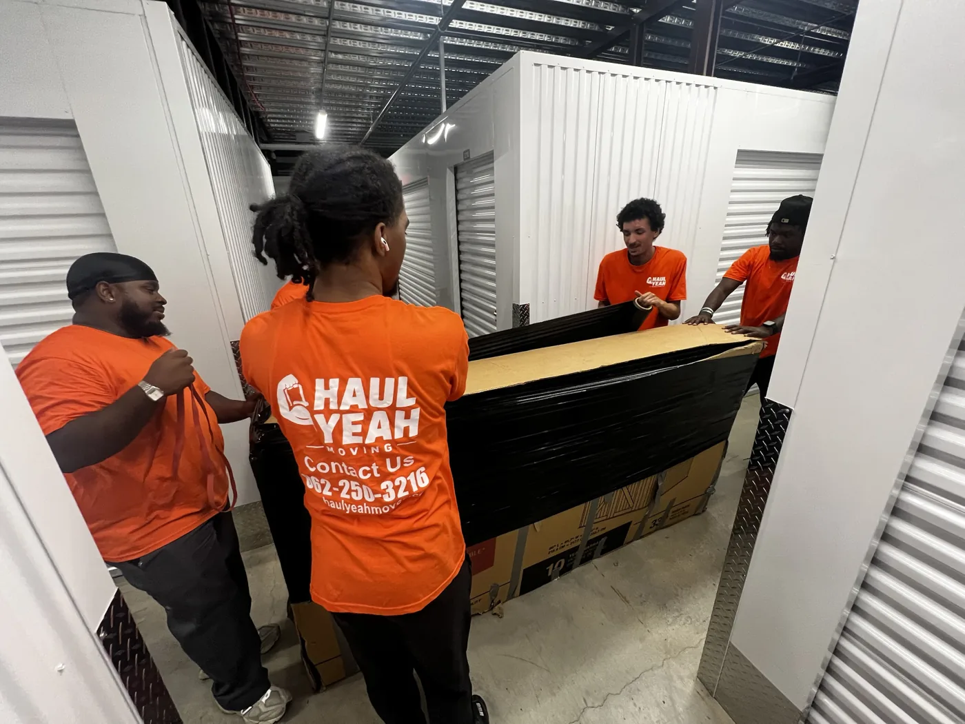 Haul Yeah Moving crew carrying a wrapped item through a facility on a New Jersey job