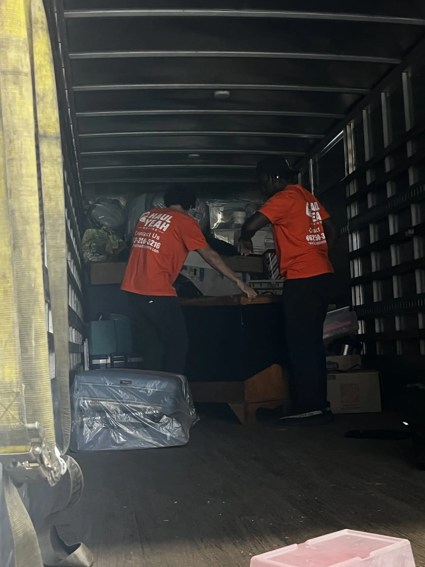 Haul Yeah Moving crew loading and stacking furniture inside a box truck on a New Jersey move